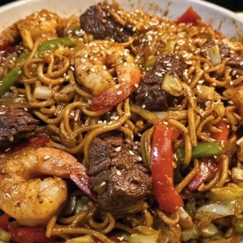Honey Garlic Steak served with shrimp lo mein, a delicious fusion dish.