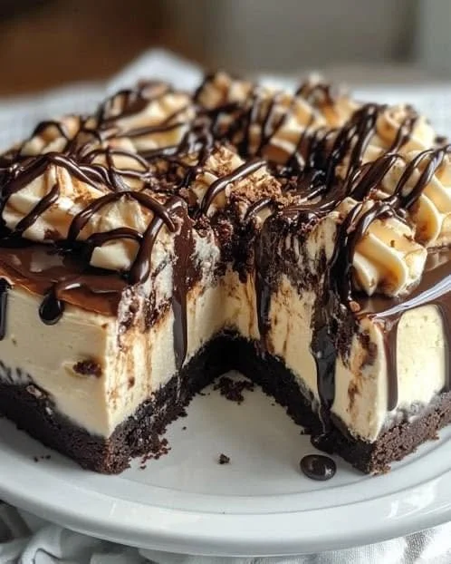 Hot fudge sundae brownie cheesecake topped with chocolate sauce and whipped cream