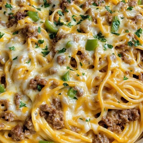 Philly cheesesteak ground beef spaghetti skillet topped with cheese in a pan.